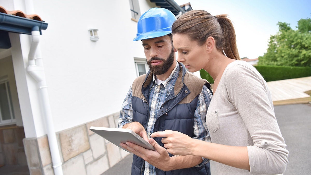 A technician showing a woman his electronic tablet