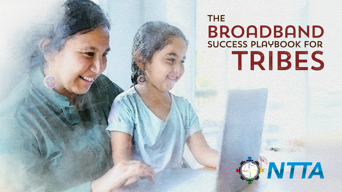 A tribal mother and young daughter smiling while viewing a laptop