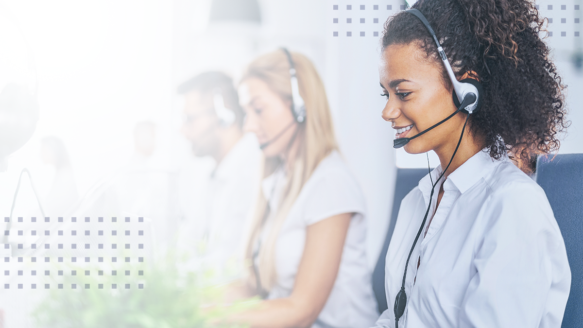 A smiling woman in an office wearing a headset