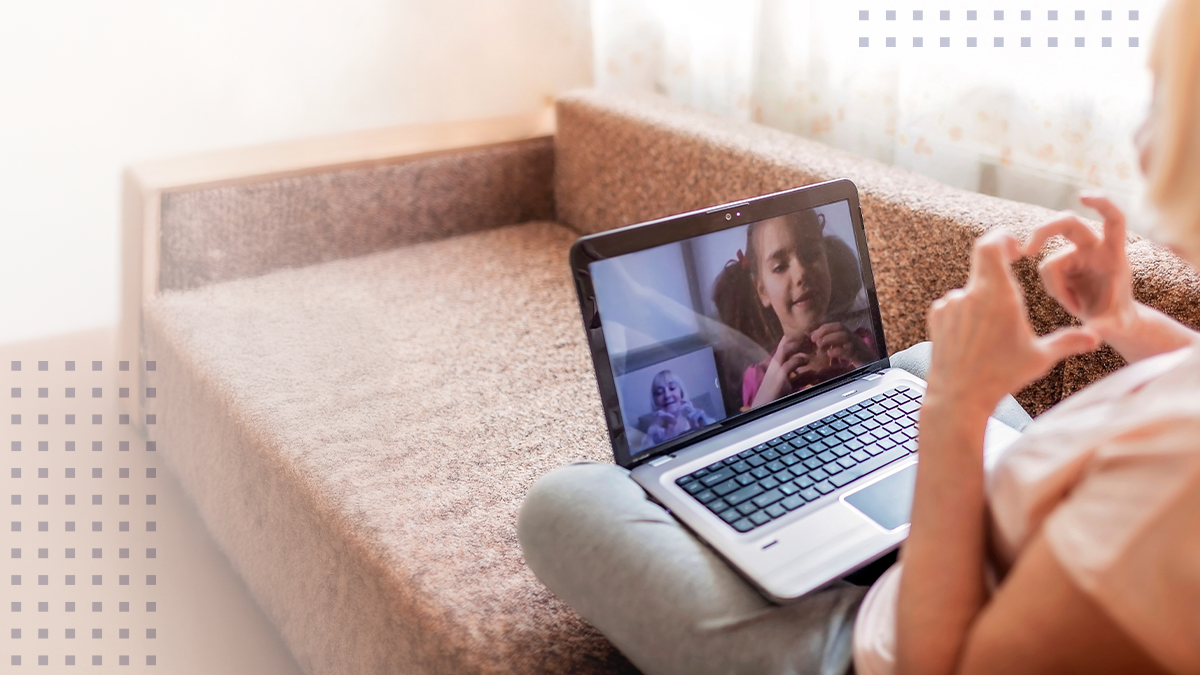 Cute girl talking with her grandmother within video chat on laptop