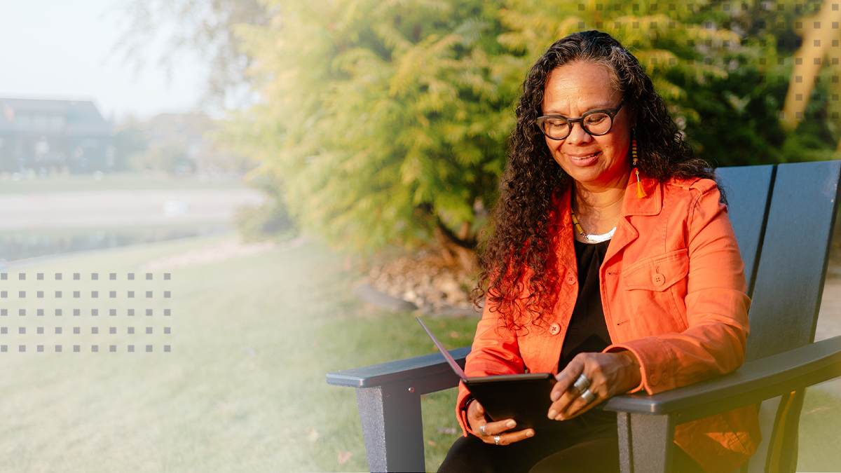 A woman browsing online with a tablet outside using tribal broadband service