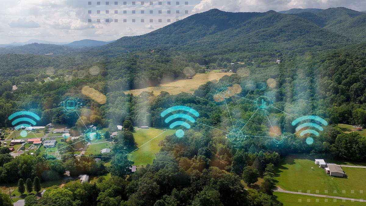 Aerial view of a town surrounding green forest and mountains with wifi connectivity