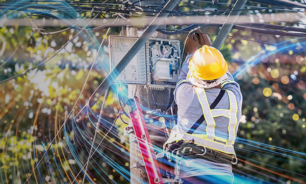 Technician installing the network cables on the pole with electrical board 