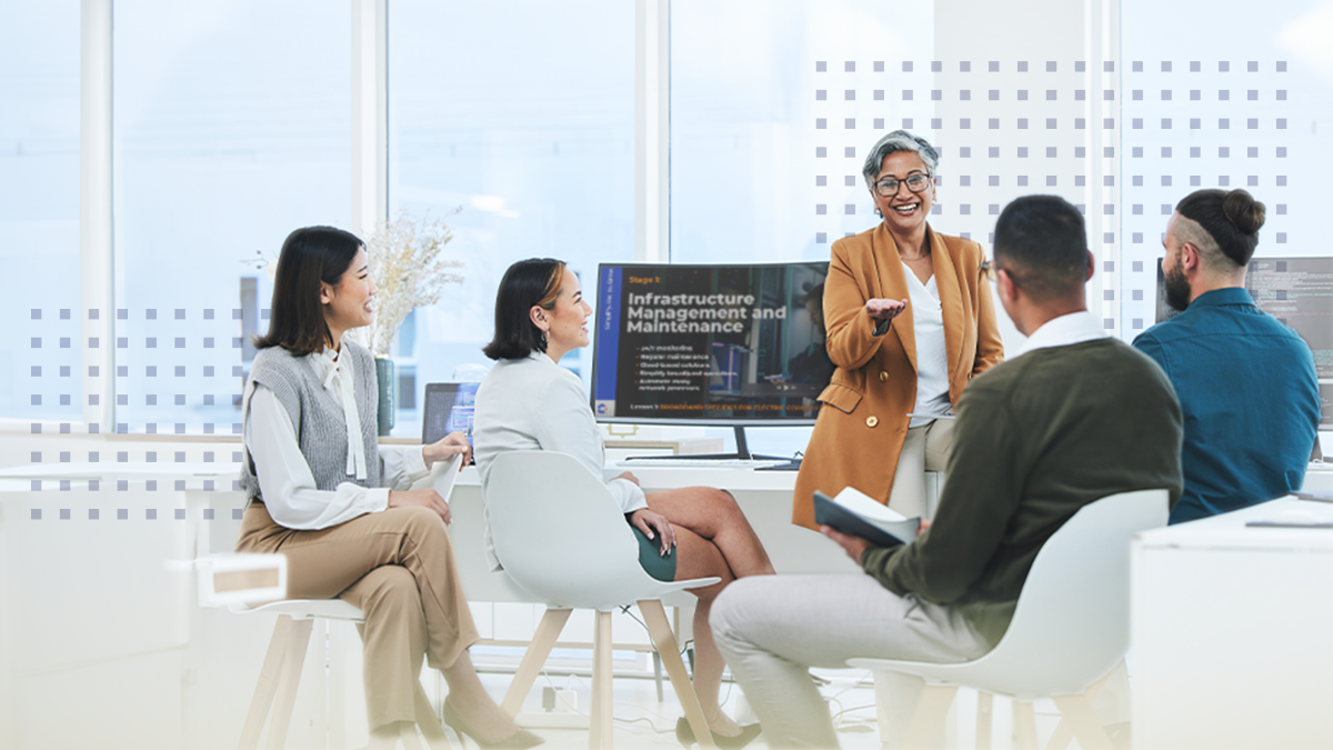 A woman presenting to a group of young adults using a display monitor