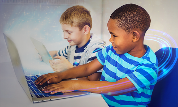 Smiling kids using a laptop and a tab in the classroom