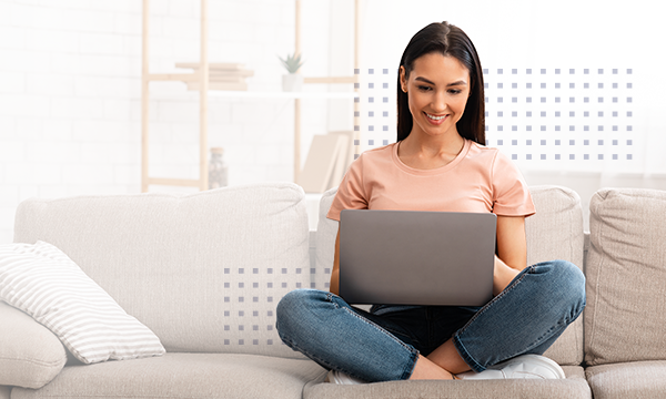 Woman using laptop phone sitting on sofa