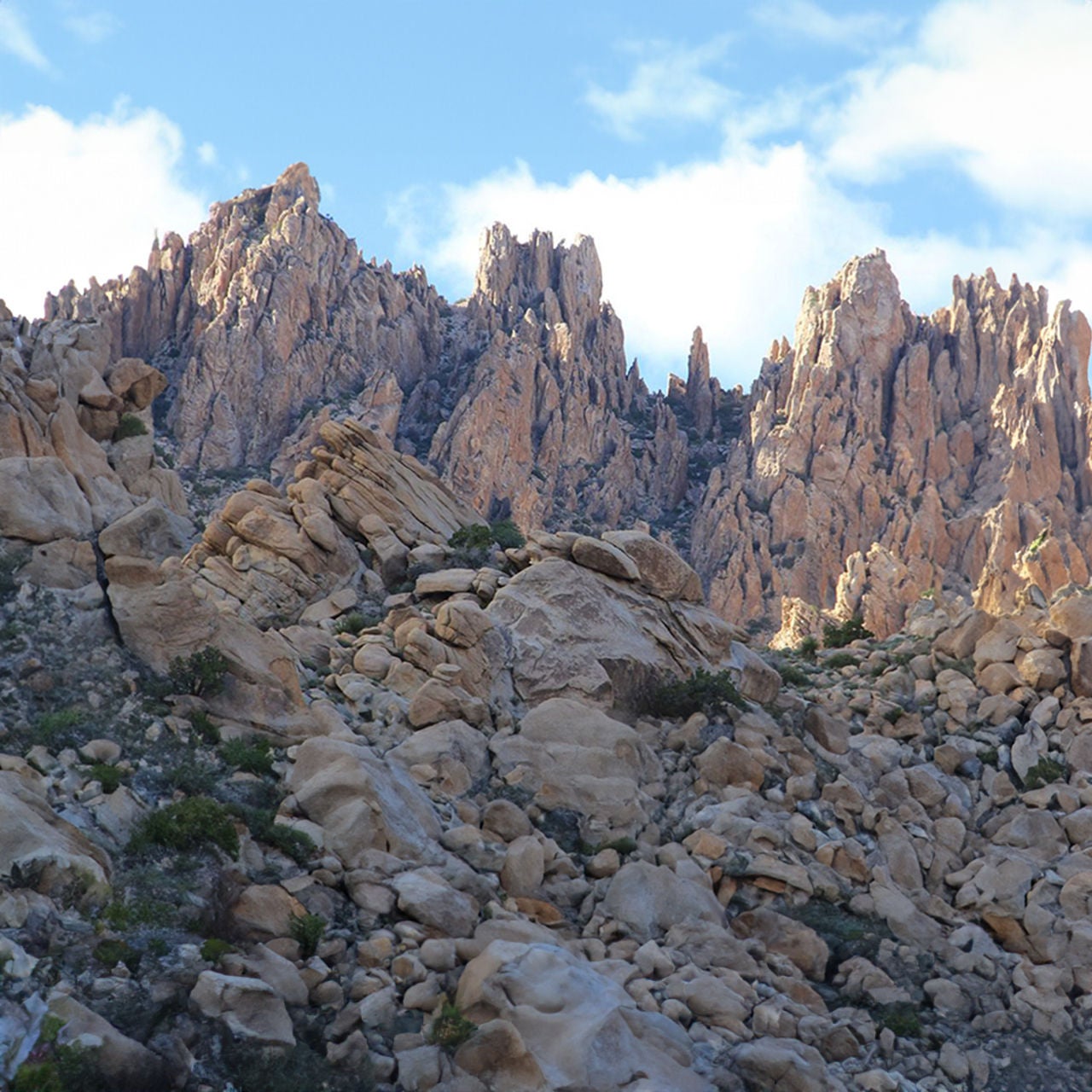 A rock landscape with large mountains and a blue sky